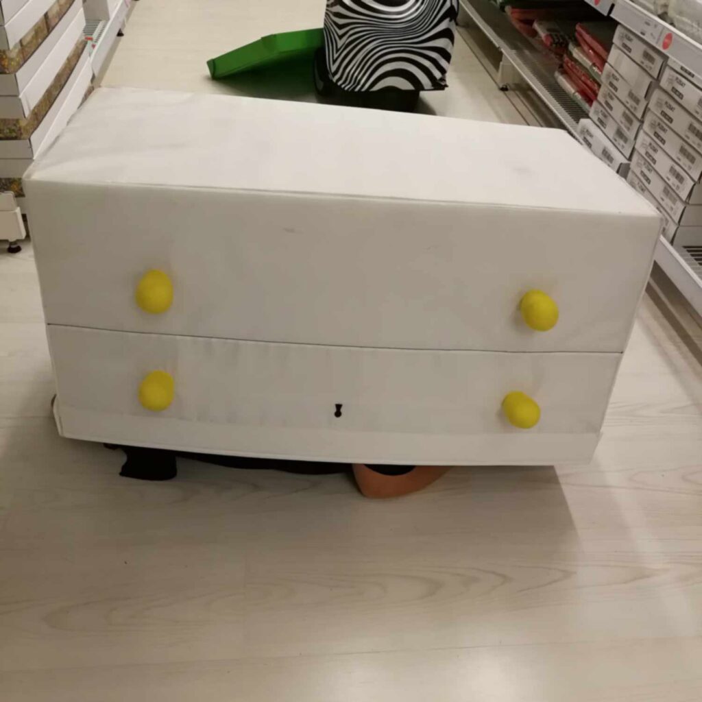 Jennifer ihopkurad i en låda på IKEAs golv